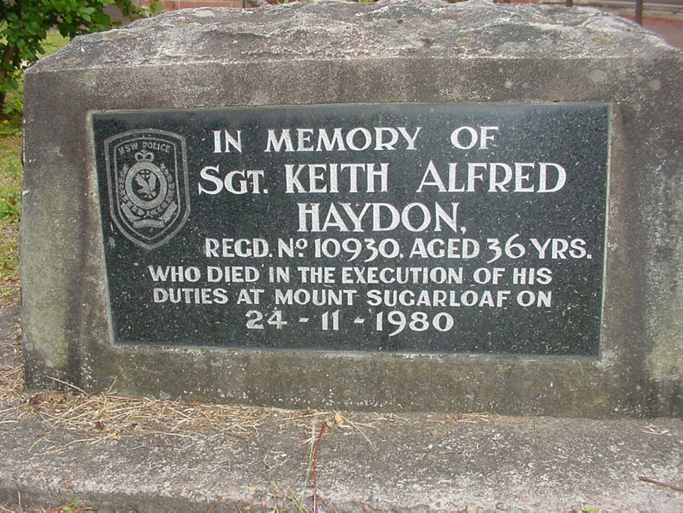 Plaque commemorating death of Sgt Keith Alfred Haydon in grounds of old West Wallsend Police Station - 10-12 Withers Street, West Wallsend.<br /> Photo Ref: 25216<br /> Creator: Clark, Mr Greg<br /> Sergeant. Keith Haydon was in charge of West Wallsend Police Station, when he was killed whilst on duty at Mt. Sugarloaf in 1980. This memorial plaque was originally placed at the spot where Sergeant Haydon was killed, but was relocated to the grounds of the West Wallsend Police Station after it was damaged by vandals. When the station closed in 2006, the plaque was moved to Waratah Police Station and rededicated in a service held 8th December 2006.<br /> Creative Commons License<br /> This work by Lake Macquarie City Library is licencsed under a CCA