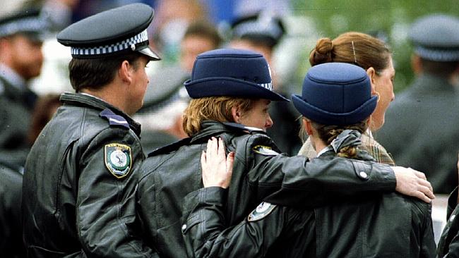  Uniformed police link arms at funeral of colleague Senior Constable Addison. 