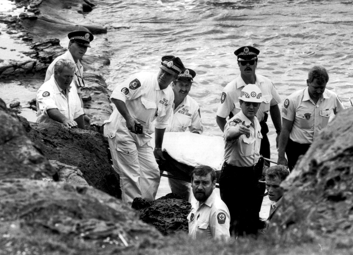 RESCUE AT WOLLONGONG LIGHT HOUSE A/O BOB LEWIS, CST MARK MULREADY, SENSGT TED DOHERTY, SENCON GARY THOMPSON, PARAMEDIC STEVE POLLARD, CST TONY FERRIS, A/O KEVIN DENT (POINTING), PARAMEDIC TERRY MORROW, A/O ANDREW GROVES (PARTIALLY HIDDEN ON LOWER RIGHT) 1988