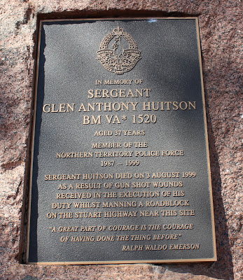 Front Inscription Glen Huitson Park This park was named in memory of the late Sgt. Glen Anthony Huitson BM,VA, Service No. 1520 on 3 August 2000. Sgt. Huitson was the officer in charge of the Adelaide River Police Station. He died on 3rd August 1999 as a result of gun shot wounds received in the execution of his duties whilst manning a roadblock on the corner of the Stuart Highway and Old Bynoe Road. Twice Decorated as a serving Police Officer, Glen Huitson lived his personal life with the same intensity, and was an integral part of community life in Adelaide River. His untimely death has a left a gap in this community which will never be filled. Glen is survived by his Widow Lisa and children Joey & Ruby. Citizens of the Coomalie Region joined with serving Members of the Northern Territory Police Force at this site on 3rd August 2001 to dedicate this memorial stone on the occasion of the second anniversary of Sgt. Huitson`s death. We honour the life and the achievements of a remarkable citizen. May He Rest In Peace