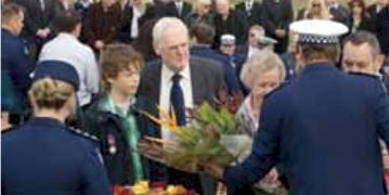 Jack Bateman and his grandfather, Phil Bateman, place flowers at the memorial service