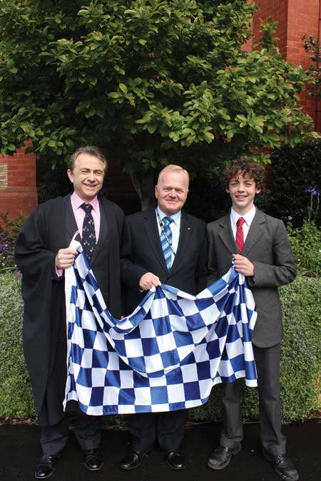 Principal Tom Batty, Mr Neil Soullier OAM and Jack Bateman (Year 7) with the Blue Ribbon flag of remembrance.