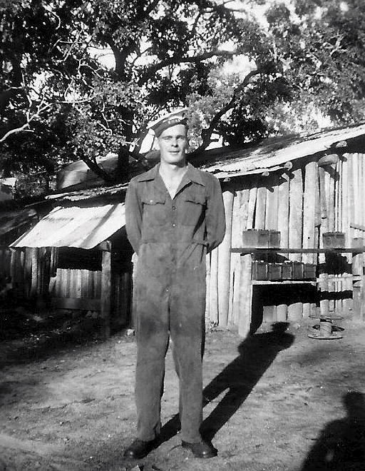 Copy write (From the private collection of William Jones) Craftsman Ivan Bedelph (TX13568) of the 281st L.A.D., 12th Infantry Bde, 1943-45 outside the battery shack at 39 Mile. With 6 volt systems in vehicles prevalent during the war in Australia, the amount of batteries a unit must have gone through would have been incredibly high hence the number stacked up waiting to be charged at right of photo.