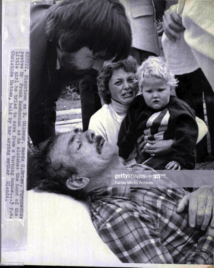 Paramedics revive Mr. Frank Bowhannan as he clutches the hand of the little girl he tried to save from a burning house... 3 y.o. Christine Hatton, held by her crying mother Glenda.A Little girl wept today for an old man who had twice risked his life entering a blazing house trying to save her.Mr. Frank Bowhannan, of First Avenue, Seven Hills, thought his next door neighbour's child, Christine Hatton, 3, had been trapped in the house.He and policeman Const. Jeff Bakhuizen twice entered the house searching for Christine before they were forced out by intense heat and smoke. July 22, 1982. (Photo by Barry James Gilmour/Fairfax Media via Getty Images).<br />
