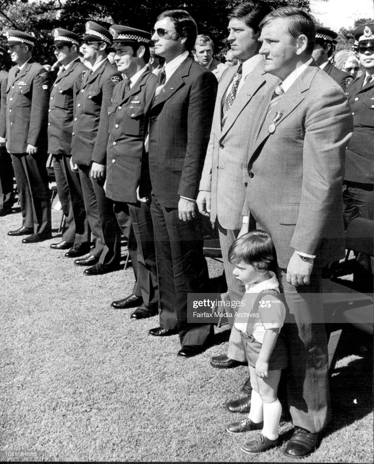 23 months old son of Tunstall, Mathew could not resist to join his father despite the strict protocol and National Anthem during the ceremony. On the right side of Tunstall are Detective Sen.Const Aldo Lorenzutta and further Det Sen Const Geoffrey Neil McDowell, awarded with Queens Commendation for Brave Conduct . Queens' Awards at the Government House today. Detective Senior Constable Wilfred Tunstall awarded with Queens Gallantry Medal. Two-year-old Matthew Tunstall ignored protocol and the national Anthem to run to his father, Detective Senior Constable Wilfred Tunstall who was awarded the Queen's Gallantry Medal at Government House yesterday, April 18, 1977. (Photo by Antonin Cermak/Fairfax Media via Getty Images).<br />
