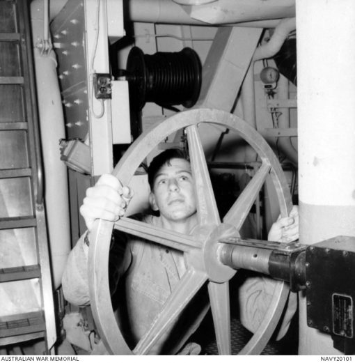 The RAN destroyer HMAS Brisbane (II) D41 is on its first deployment to Vietnam, operating on the gunline with the US Seventh Fleet. Here R94632 Leading Engineering Mechanic (LME) Alan Francis Gale opens a valve on the main cooling circulation system in the engine room of HMAS Brisbane.