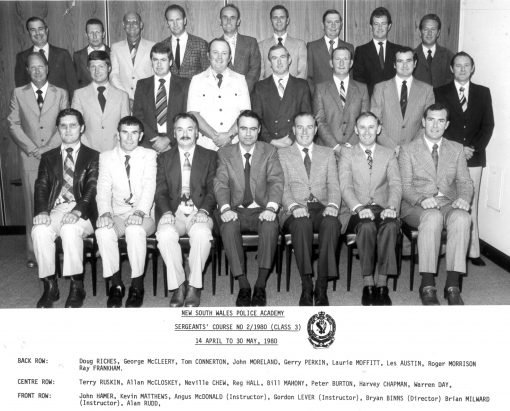 NSW Police Academy. Sergeants' Course #2/ 1980 ( Class 3 ) 14 April to 30 May 1980 <p>Back Row: Doug RICHES, George McCLEERY, Tom CONNERTON, John MORELAND, Gerry PERKIN, Laurie MOFFITT, Les AUSTIN, Roger MORRISON, Ray FRANKHAM. <p>Middle Row: Terry RUSKIN, Allan McCLOSKEY, Neville CHEW, Reg HALL, Bill MAHONY, Peter BURTON, Harvey CHAPMAN, Warren DAY. <p>Front Row: John HAMER, Kevin MATTHEWS, Angus McDONALD ( Instructor ), Gordon LEVER ( Instructor ) Bryan BINNS ( Director ), Brian MILWARD ( Instructor ), Alan RUDD